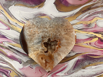 agate crystal heart with small chip on marble pink background